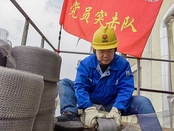 5月10日中午，在動力車間三期工藝除氧器平臺上，黨員突擊隊(duì)隊(duì)長李鑫正在纏繞新填料.jpg
