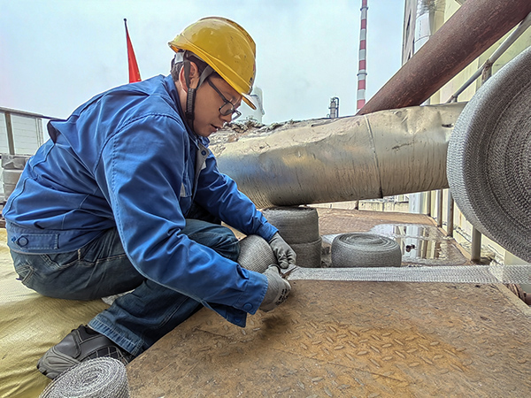 5月10日中午，在動力車間三期工藝除氧器平臺上，黨員突擊隊(duì)隊(duì)員劉瑞斌正在纏繞新填料.jpg