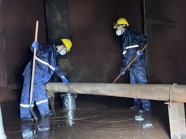 將熱水槽底部污水鏟倒廢桶中，用廢桶搬運出去.jpg