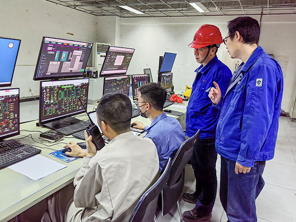 5月13日，動力車間三期鍋爐控制室，DCS改造工藝、儀表、電氣等部門聯(lián)合調(diào)試，車間主任姜軍虎與技術(shù)員畢加佳查看調(diào)試過程.jpg