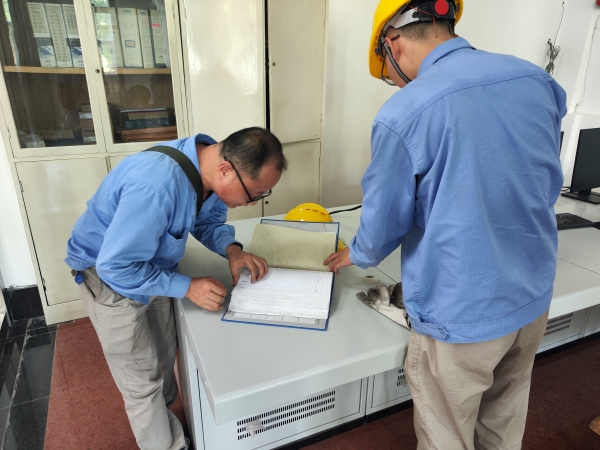師帶徒，8月21日，老師傅王益在一期控制室為新員工胡含朗講解儀表設備圖紙.jpg