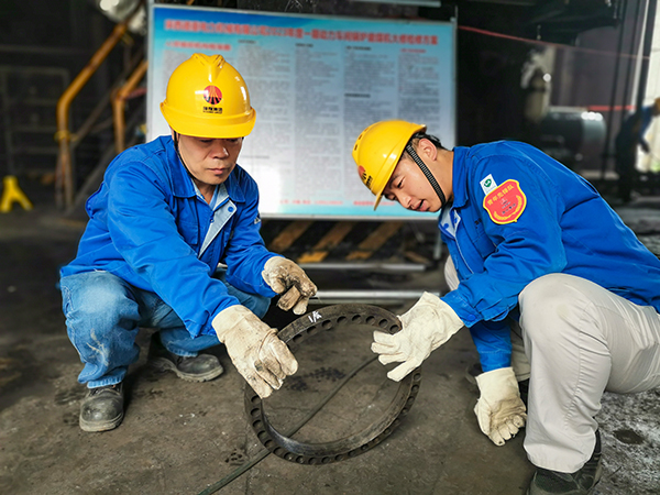圖三：12日下午14時(shí)，在一期磨煤機(jī)廠房，陜西省技術(shù)能手姬霄給青工張跟潮講解磨煤機(jī)搖臂曲拐內(nèi)環(huán)及動(dòng)作原理。.jpg